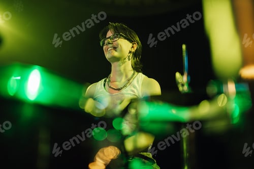 Preview: Drummer playing with passion on illuminated stage