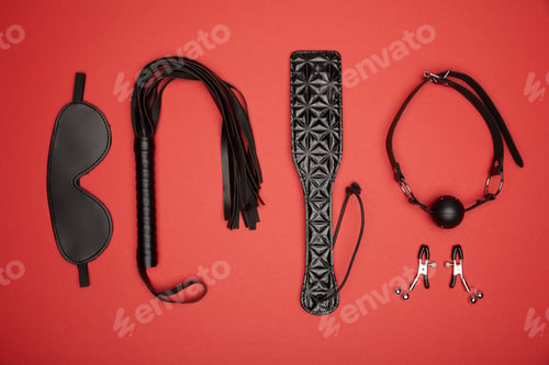 Preview: flat lay with various black sex toys isolated on red
