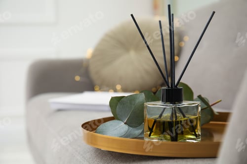 Preview: Aromatic reed air freshener and eucalyptus branch on tray in living room. Space for text