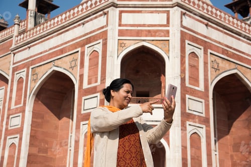 Preview: Indian woman taking selfie with smartphone in front of Humayun's Tomb