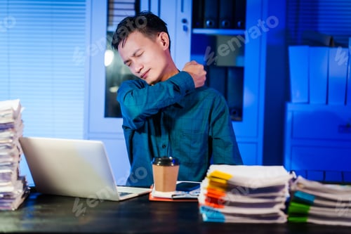 Preview: An Asian businessman works late at night in the office,dealing stress,migraine headaches,overtime