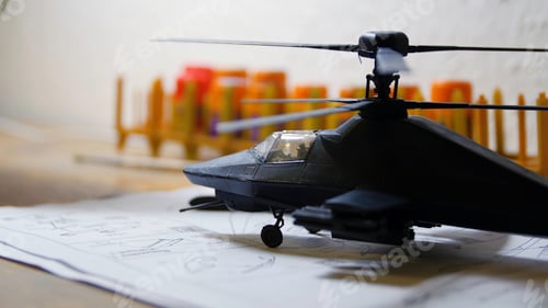 Preview: Toy Military Helicopter on wooden table. Small army helicopter hobby model toy on the table. Toy