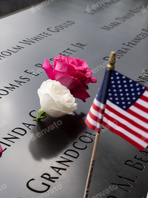Preview: Vertical closeup shot of an American flag and roses on a gravestone