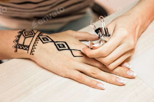 Preview: Artist applying henna tattoo on women hands. Mehndi is traditional Indian decorative art. Close-up