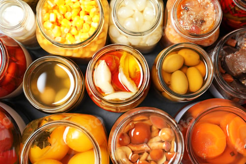 Preview: Open jars with pickled vegetables on grey table, flat lay
