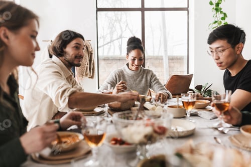 Preview: Young colleagues happily discussing work having lunch together