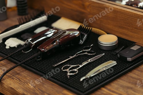 Preview: close-up view of set of professional barber tools on wooden shelf in barbershop