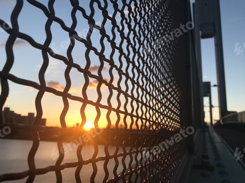 Cityscape View Through Fence at Sunrise