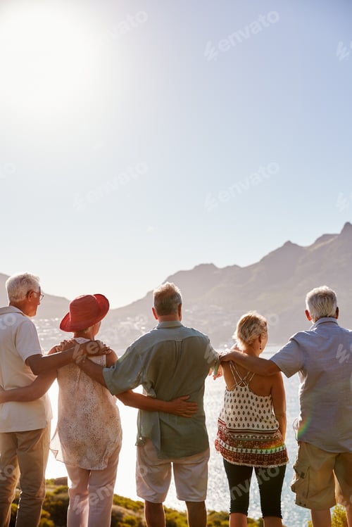 Preview: Rear View Of Senior Friends Visiting Tourist Landmark On Group Vacation Standing On Wall