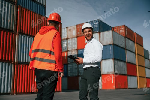Preview: Two male workers is on the location with containers