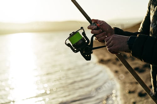Preview: Fisherman hands holding fishing rod close up