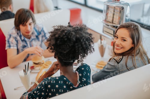 Preview: Young multiracial friends enjoying in the diner