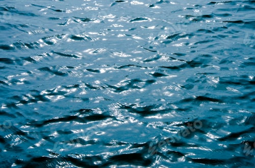 Preview: sea wave close up, low angle view.Blue water ripples texture with dark and light area.Surface of the