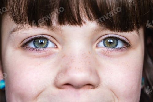 Preview: Close-up of child's freckled face with expressive eyes