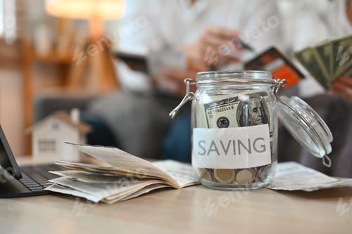 Preview: Glass jar with dollar banknotes and coins on table. Saving money concept