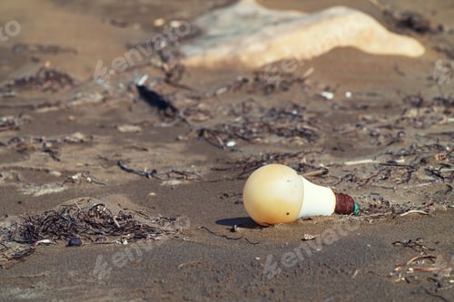 Preview: Rusty LED light bulb in the sand