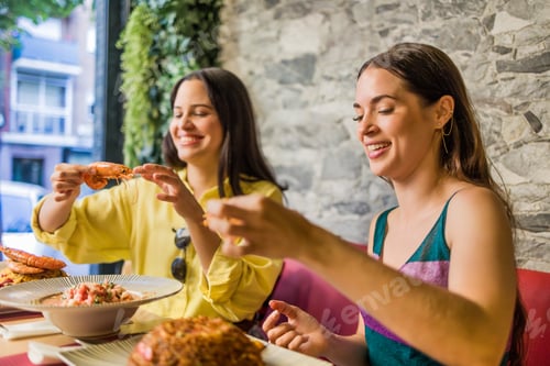Preview: Latinx female friends together eating happy in a Ecuadorian food restaurant. Traditional meal
