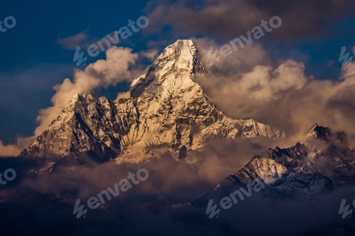 Preview: Peak of Ama Dablam mountain in clouds and fog with snow reflecting sunlight