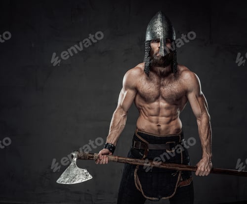 Preview: Naked and furious viking posing with his axe in studio