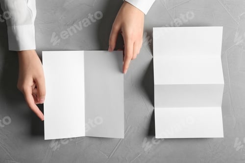 Preview: Woman with blank brochures on grey background, top view. Mockup for design