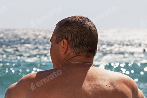 Preview: Close-up of a man from the back looking at the sea