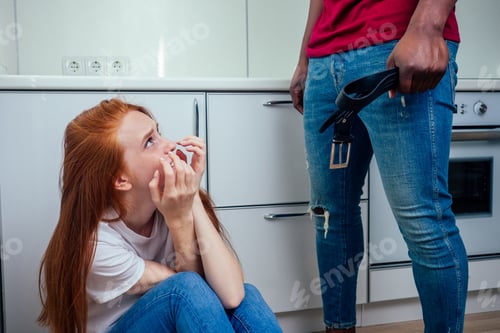 Preview: domestic violence. angry african american man hitting girl with bottle of alcohol at kitchen
