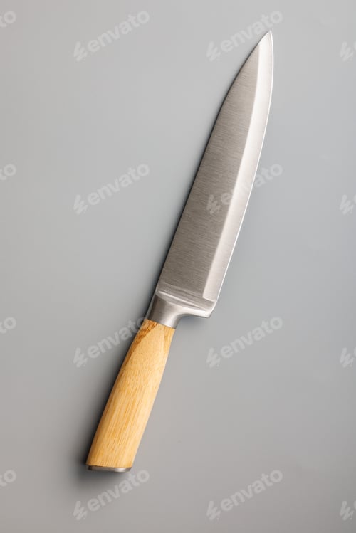 Preview: Kitchen knife on gray background. Top view.