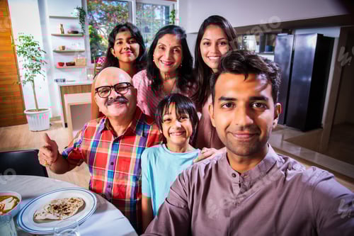 Preview: Indian asian multigenerational family posing for selfie picture after having lunch at home
