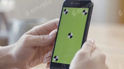 Preview: Close up of woman hands holding smartphone with green screen display in verical position. Stock