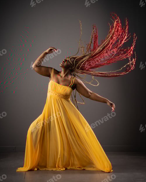 Preview: African American female wearing a bright yellow dress with her long red hair blowing in the wind