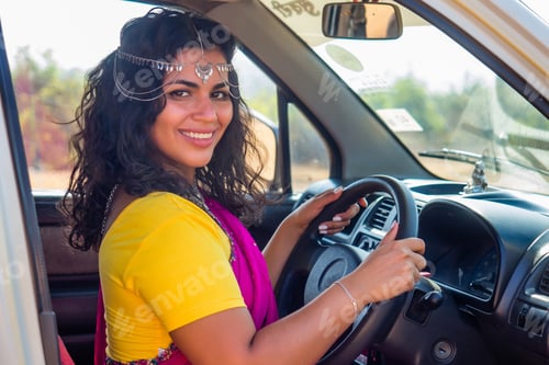 Preview: relaxed indian woman in a traditional pink sari and costume jewelry on summer travel