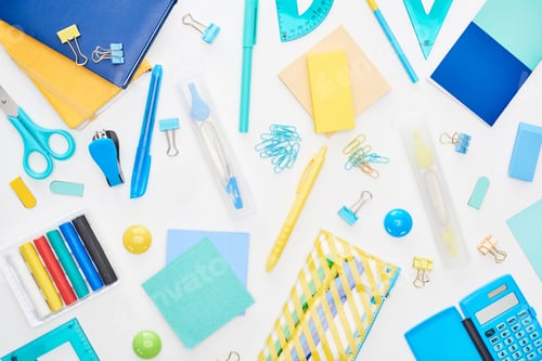 Preview: Top view of blue and yellow scattered school supplies with notepads, pencil case and calculator