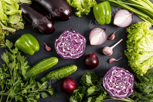Preview: organic raw vegetables of green and purple color on a black background. top view. flat styling.