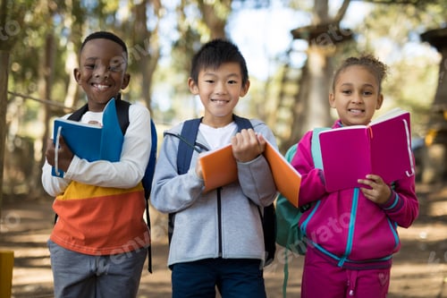 Preview: Portrait of kids holding book in park