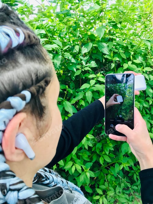 Preview: A girl with blue braids using white Bluetooth wireless headphones. || Outdoors || Natural light