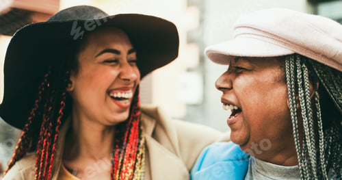 Preview: Happy african mother and daughter with braids having fun outdoor wearing trendy clothes