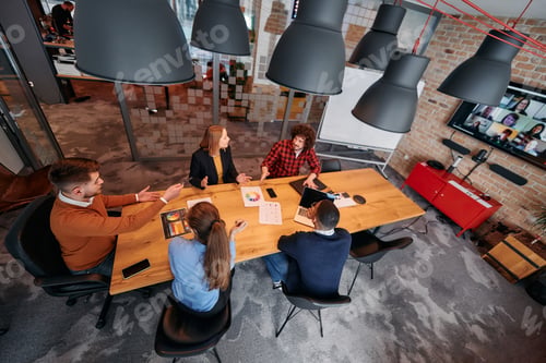 Preview: Top view of a modern startup office, a diverse team of business professionals engage in discussions
