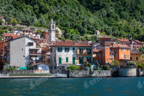 Preview: Scenic view of colorful buildings and a church tower along the shoreline of Lake Como, Italy