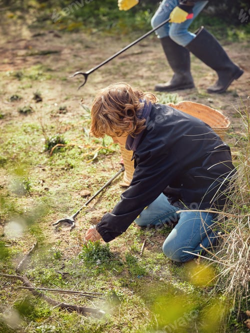Preview: Preteen boy picking up garbage in ground with trash grabber