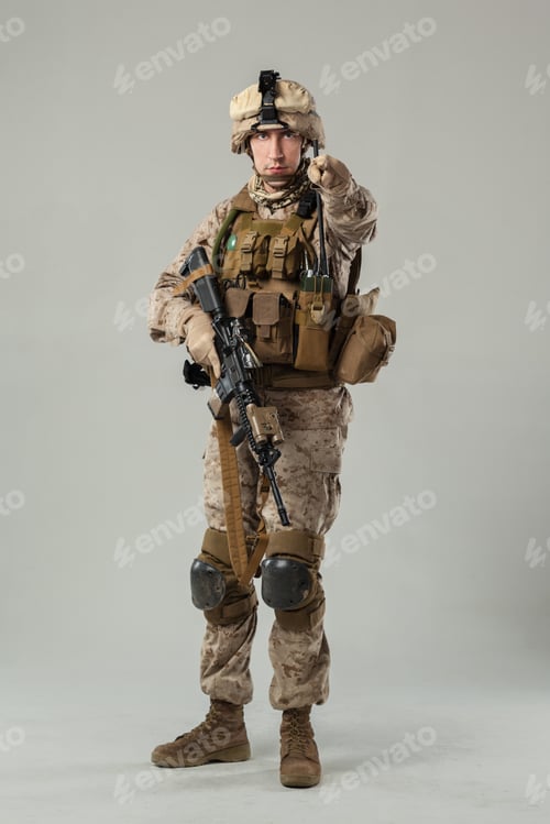 Preview: Soldier stands with weapon pointed and eyes focused in a studio setting