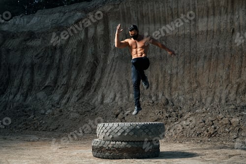 Preview: Powerful man with muscular body training legs outdoors