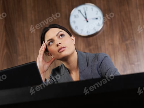 Preview: Business woman sitting at desk thinking