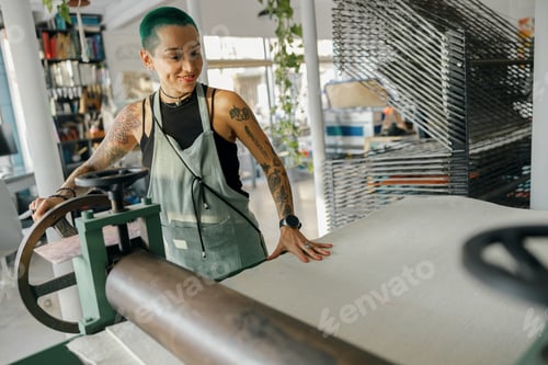 Preview: Female worker in apron use special equipment while working on design studio