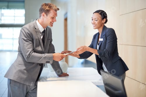 Preview: Clocking in for the day. A businessman signing in at a reception desk.