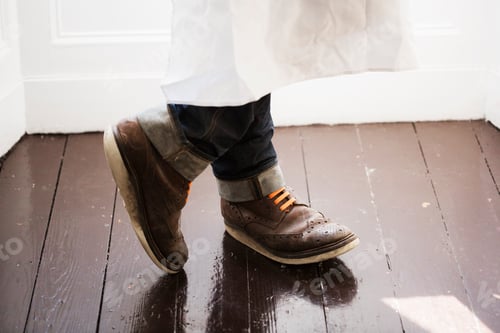 Preview: Close up of a man's feet, wearing brown shoes with orange shoe laces.
