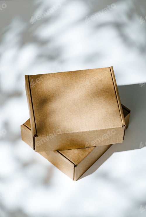Preview: Freshly packed cardboard boxes resting on a white surface, illuminated by soft natural light