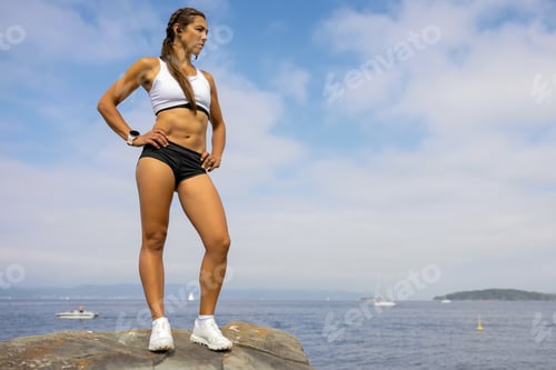 Preview: Fit Woman In Sportswear Looking Away While Standing On Rock