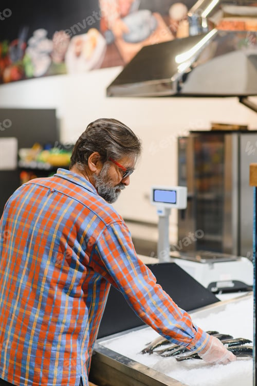 Preview: Man choosing fresh chilled fish in grocery store