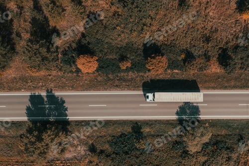 Preview: Aerial shot of freight transportation truck on road in summer afternoon, top down drone image