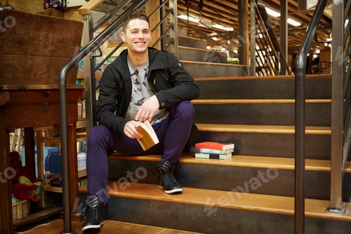 Preview: Portrait of young man sitting on book store stairway